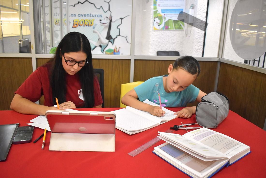 Sesión grupal de Start Smart en sucursal MatheComics Palomar, alumnos trabajando con cuadernos en mesa roja.